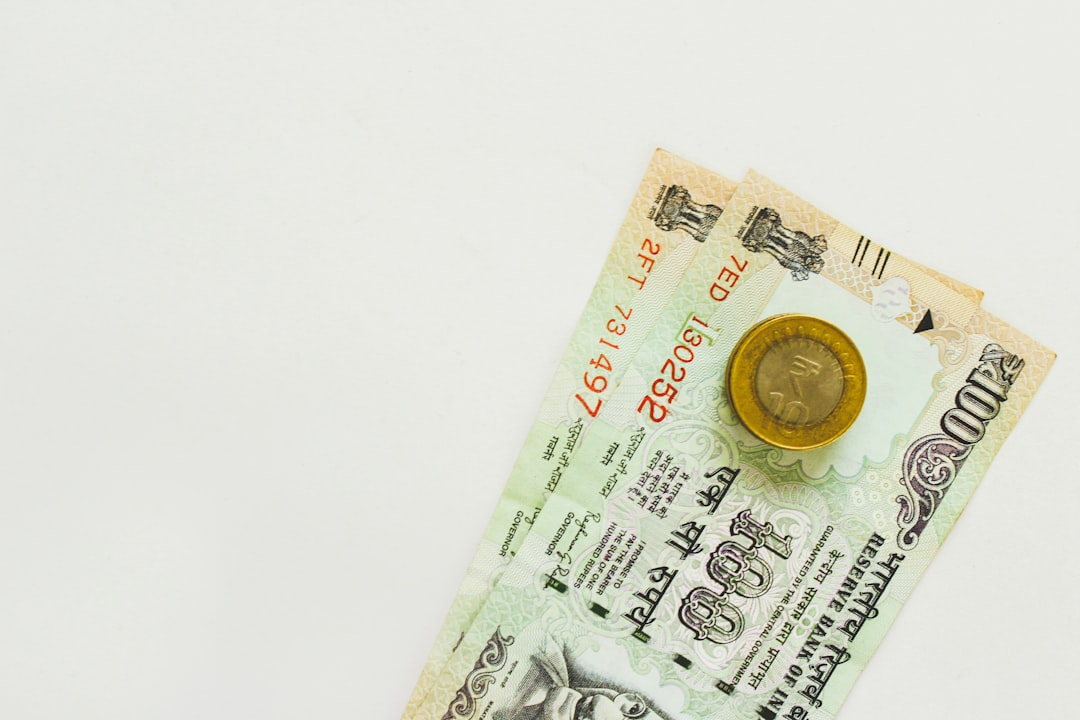 An image depicting the Indian Rupee (INR) symbol transforming into a weaker form against a strong US Dollar (USD) symbol. There should be arrows indicating FII outflow from India and a global dollar index rising. The background could show a downward trend in stock market graphs.