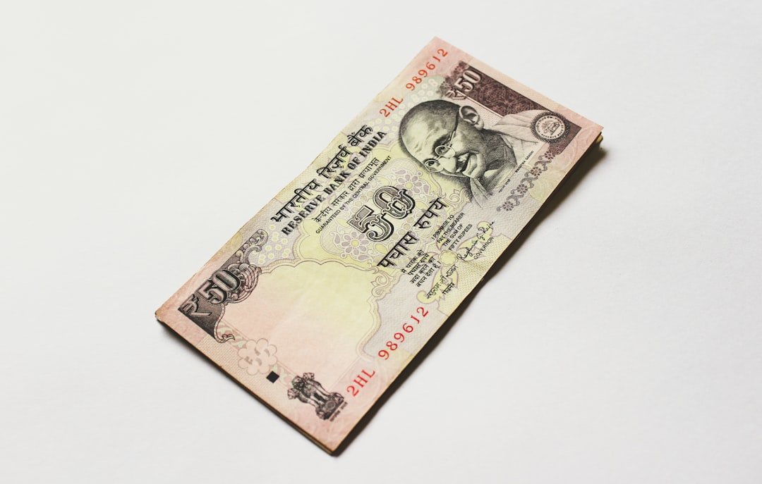 A line graph showing a sharp downward trend for Nifty 50 with a red arrow pointing down, indicating a gap down opening. The background shows images of US Fed building and Indian Parliament.